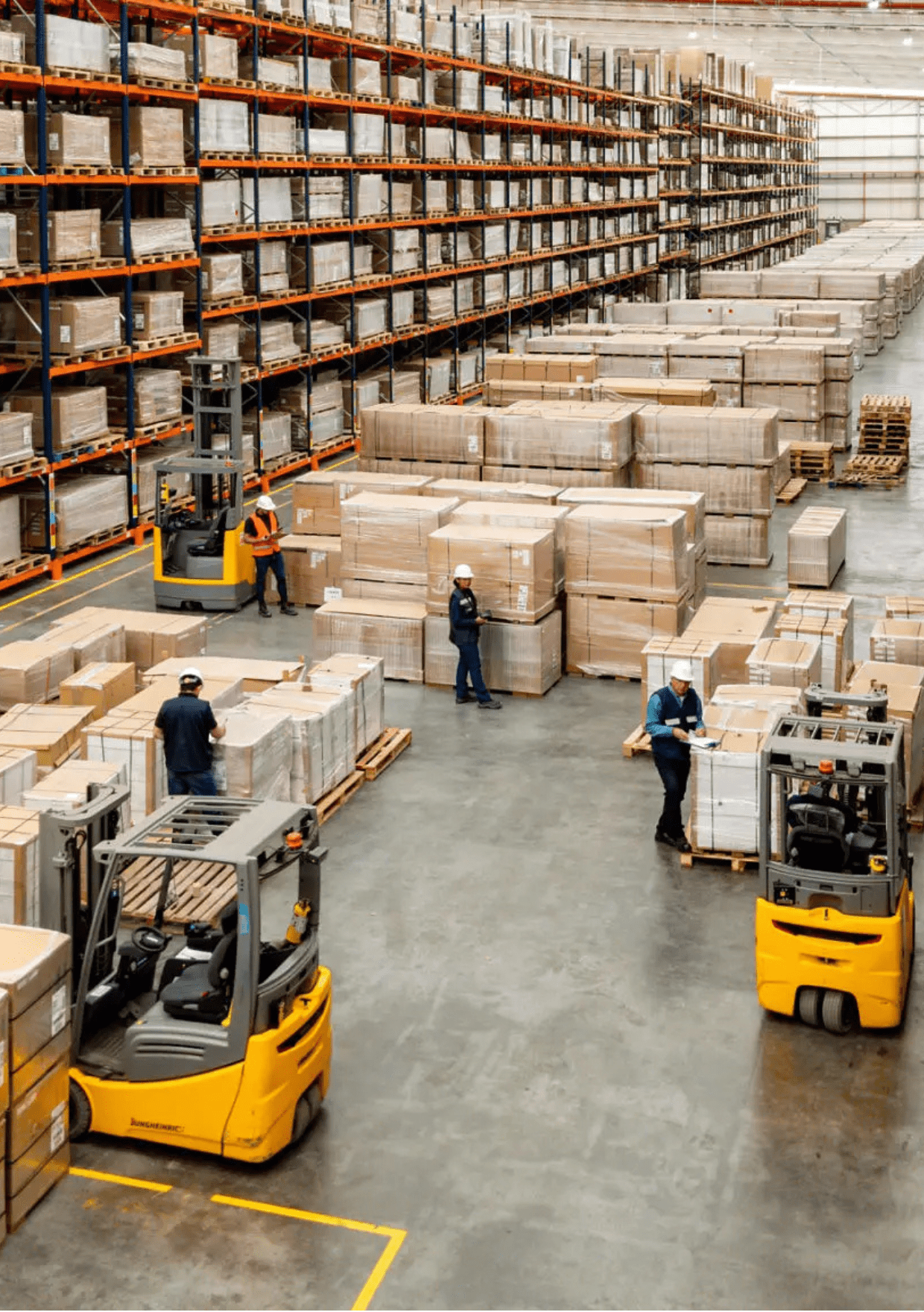 Warehouse with workers and forklifts in action.