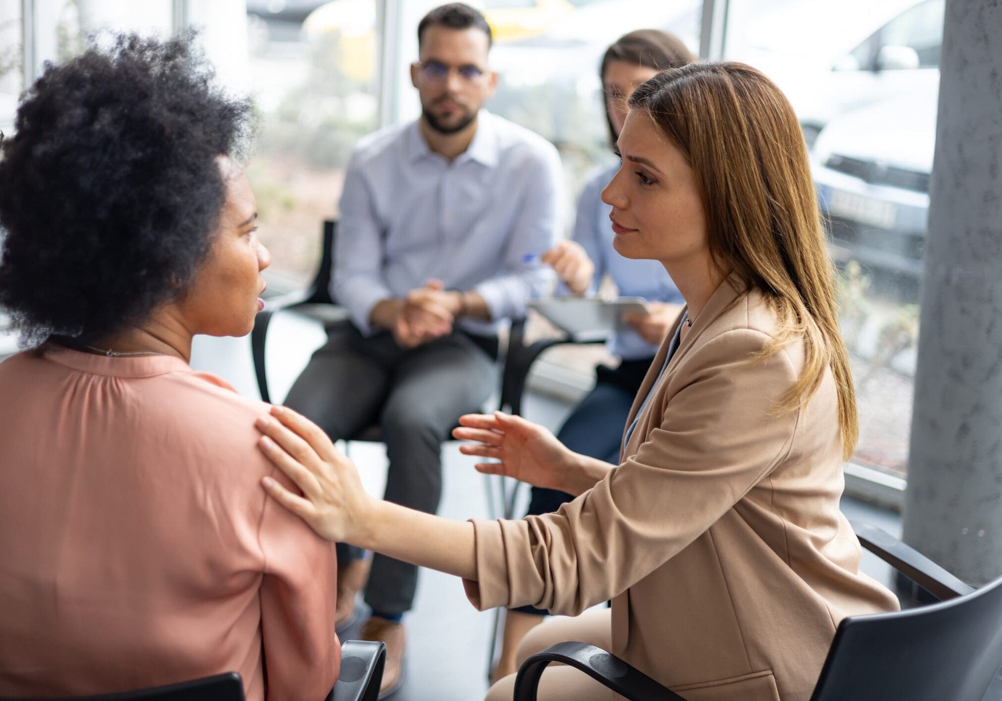 Woman comforting another in meeting